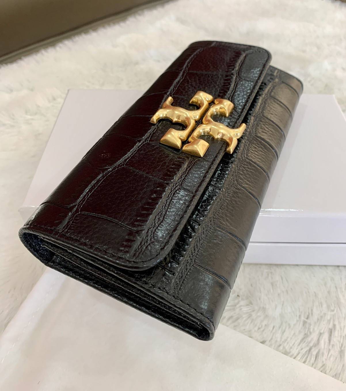 TORY BURCH Croc Long Wallet กระเป๋าสตางค์ใบยาว วัสดุหนังแกะสังเคราะห์ อะไหล่อทองโดดเด่นที่ด้านหน้า หนังเงาขึ้นรูปสวย เปิด-ปิดด้วยกระดุม ด้านในกระเป๋าแบ่งออกเป็นPatation มีช่องชิปยาวตรงกลาง มีช่องสำหรับ 6 ใบ งานสวยพร้อมส่งให้รับทรัพย์กันแล้ววันนี้