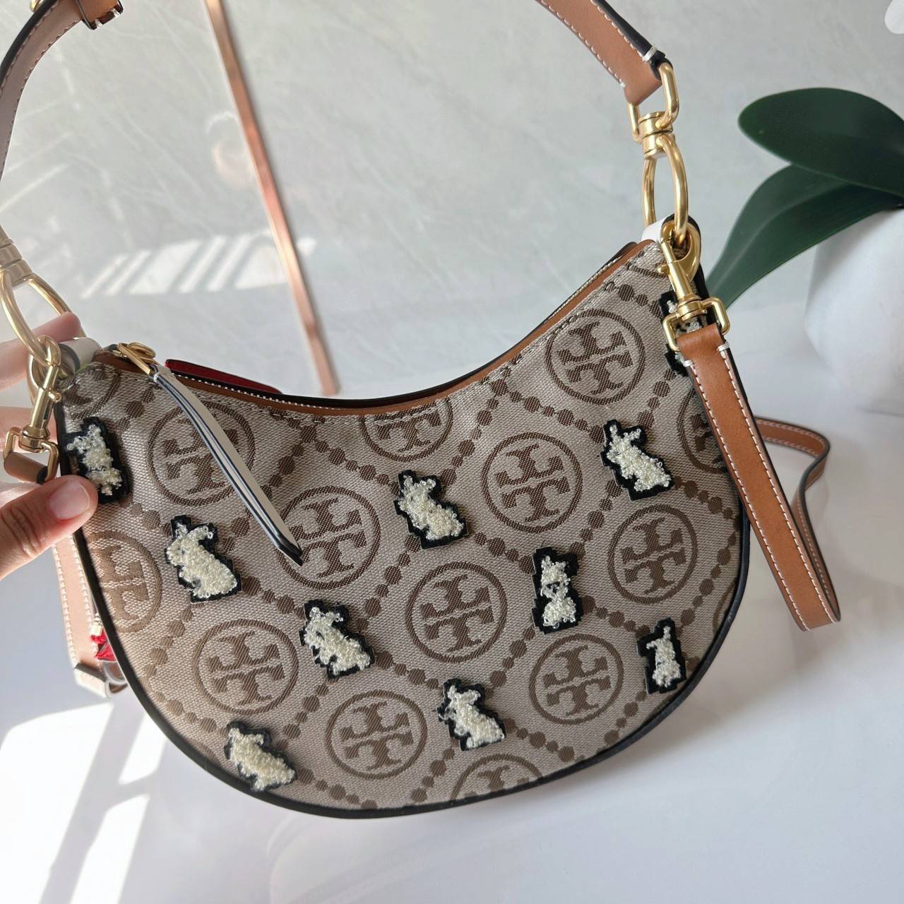 TORY BURCH Mini T Monogram Embroidered Rabbit Crescent Bag 🐇 คอลเลคชั่นกระต่ายสุดร้อนแรงแห่งปี 🥕🥕 คอลเลคชั่นทีบ่งบอกสไตล์ที่ทันสมัยทรงครึ่งวงปักลายกระต่ายบนกระเป๋าสุดน่ารัก โด่ดเด่น