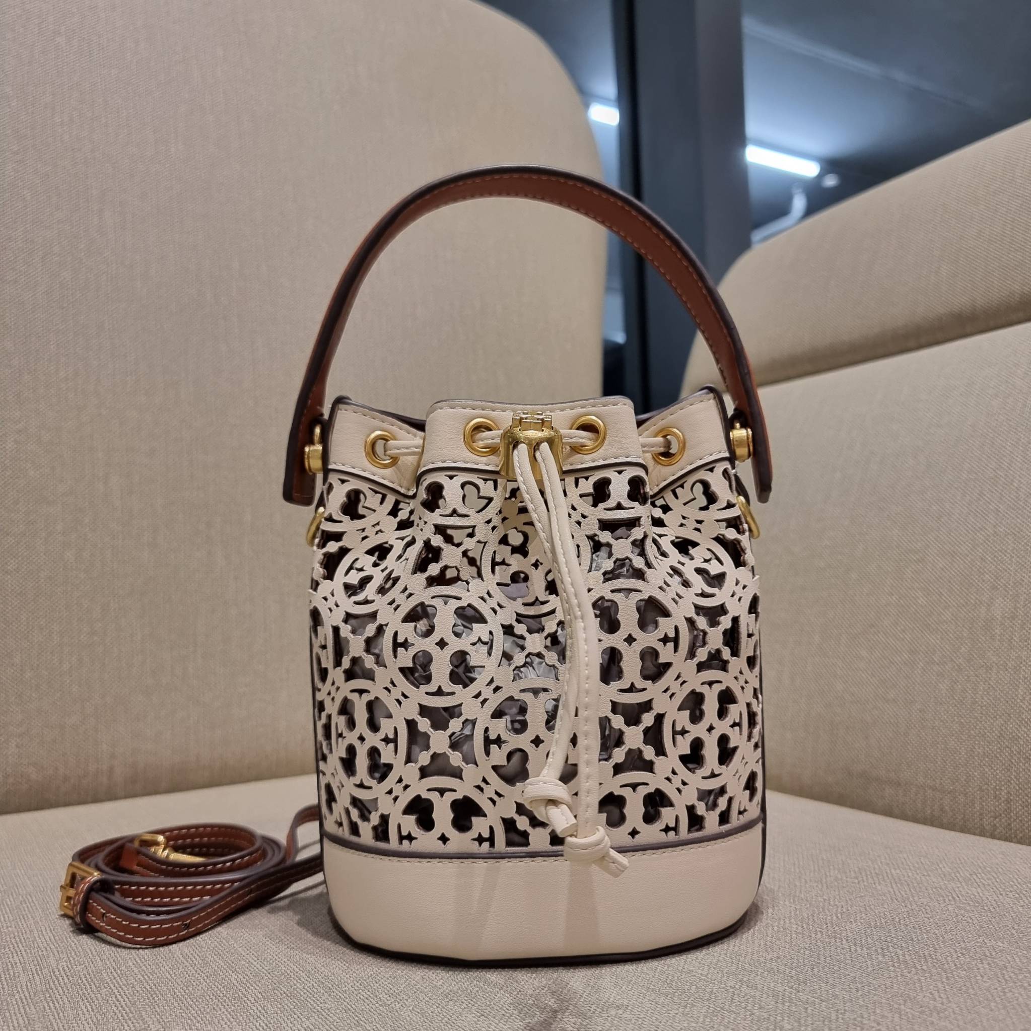 TORY BURCH T MONOGRAM LASER-CUT MINI BUCKET BAG ใจบางที่สุดกับคอลเลคชั่นนี้ กับกระเป๋าสะพายทรงบัคเก็ต ไซส์มินิ รุ่นชูโรงสุดฮิต ที่เพิ่มดีเทลความแพงด้วยการฉลุลวดลายโมโนแกรมรอบใบ ถักทอเป็นเส้นลายสานที่สวยงามมาก งานฝีมือจริงๆ วัสดุหนัง cowhide รูดเปิด-ปิดด้ว