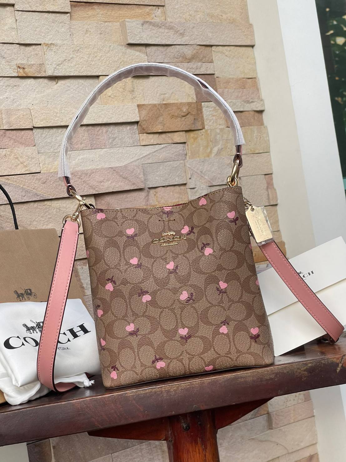 OUTTLET 】COACH SMALL TOWN BUCKET BAG IN SIGNATURE WITH Heart floral print สำหรับสาวแฟชั่นที่ชอบรายละเอียดชิคๆ ดีไซน์สุดเก๋ แนะนำเลยสำหรับกระเป๋าทรงบักเก็ตใบนี้ เชื่อว่าสาว ๆ หลายคนชื่นชอบ เป็นไอเทมที่สามารถแมทช์ได้กับเสื้อหลากหลายสไตล์ บรรจุของได้เยอะโดยท