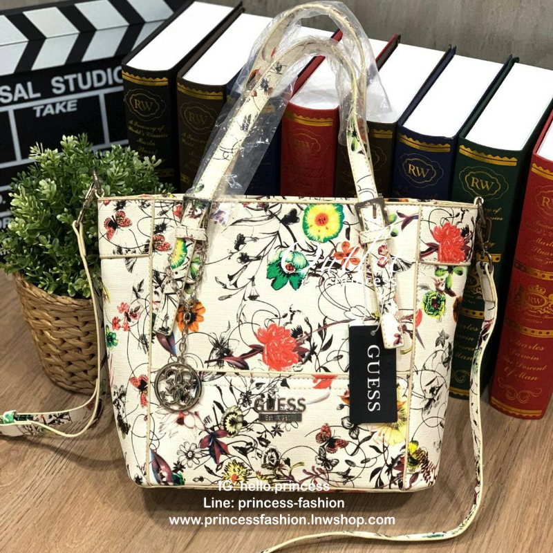 GUESS Women's Medium Floral Tote Bag กระเป๋าถือ คล้องไหล่หรือสะพาย ขนาดกลาง วัสดุหนังpu ลายดอกไม้ชนิดต่างๆรอบใบ เปิดปิดใช้งานด้วยซิปเดียวด้านบน ภายในมีกว้างใส่กระเป๋าสตาวค์ยาว มินิไอแพคได้ หูจับและสายสะพายปรับระดับได้ มาพร้อมกุญแจโลโก้guess สวยน่ารัก