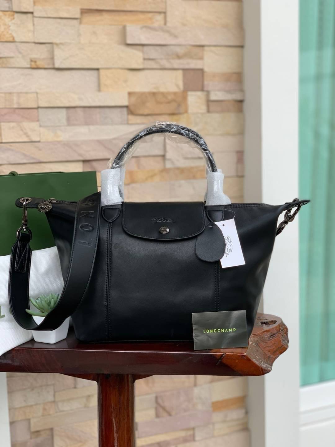 Longchamp LE PLIAGE CUIR TOP HANDLE BAG S เรียกว่าเป็นกระเป๋าอีกหนึ่งรุ่นที่ไม่ว่ายังไงก็ฮอตฮิตและติดเทรนด์ตลอดไม่เคยเปลี่ยนกับ ทรง Le Pliage Cuir หนึ่งในตระกูลกระเป๋าสุดไอคอนิกจากแบรนด์ เมื่อรุ่น Le Pliage Cuir ในรูปแบบของหนังแกะ Metis ได้ถือกำเนิดขึ้นใน