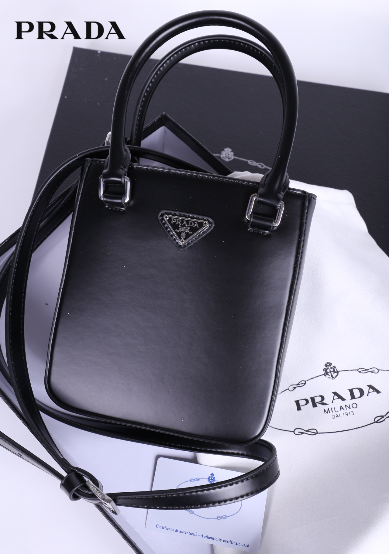 PRADA Small brushed leather tote กระเป๋าTote ขนาดเล็กที่มีดีไซน์ทรงเหลี่ยมโฉบเฉี่ยว วัสดุจากหนังเงาซึ่งเป็นวัสดุที่โดดเด่นของแบรนด์มาตั้งแต่ยุค 90'