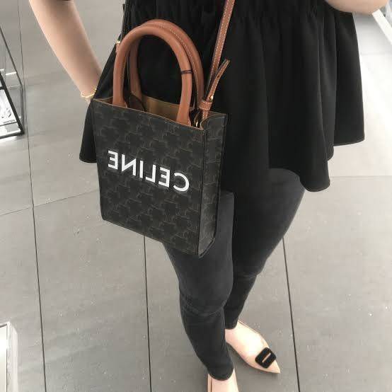 CELINE MINI VERTICAL CABAS IN TRIOMPHE CANVAS มีโลโก้ CELINE สกรีนอยู่ตรงกลาง ถือเป็นกระเป๋า Tote ที่ทำจากแคนวาสที่น่าสนใจมาก ๆ อีกรุ่นหนึ่ง และเป็นรุ่นที่ได้รับคำชื่นชมจากแฟชั่นกูรูทั้งหลายอีกด้วย หากใครที่อยากเป็นเจ้าของกระเป๋า Tote จาก CELINE สักใบ รุ่