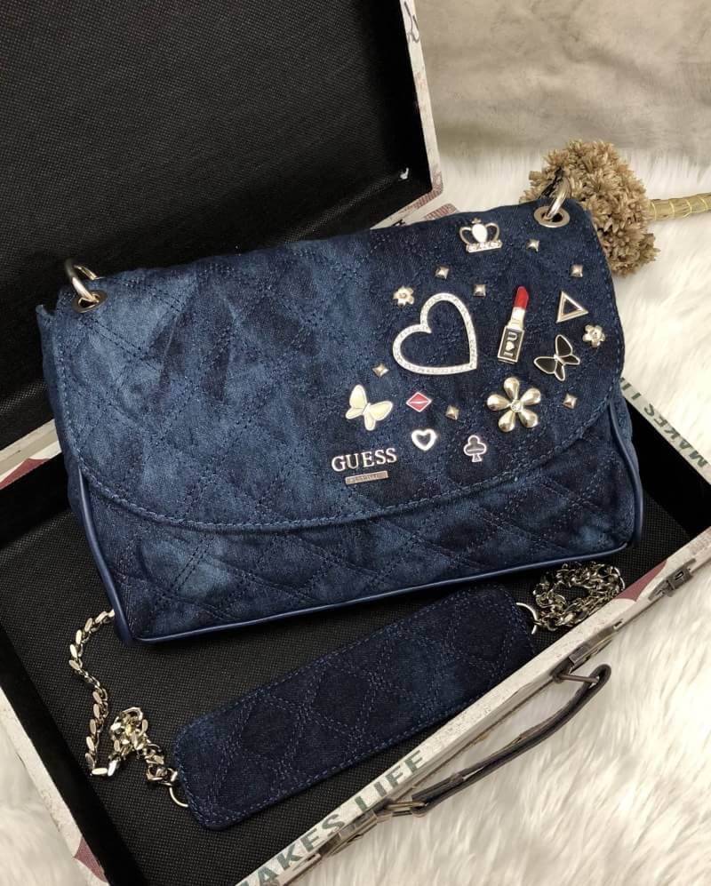GUESS WOMEN BAG JEAN กระเป๋าสะพายไหล่หรือ crossbody สุดชิค วัสดุผ้ายีนส์ ด้านหน้าติด logo brand เพิ่มดีเทลดีไซน์ตกแต่งที่ด้านหน้ากระเป๋า เปิดปิดกระเป๋าแบบแม่เหล็ก ใช้งานง่าย ภายในมี 2 ช่อง แต่ละช่องกว้างใส่ของได้จุ และยังมีช่องซิปเล็กใส่ของจุกจิกได้อีกค่ะ