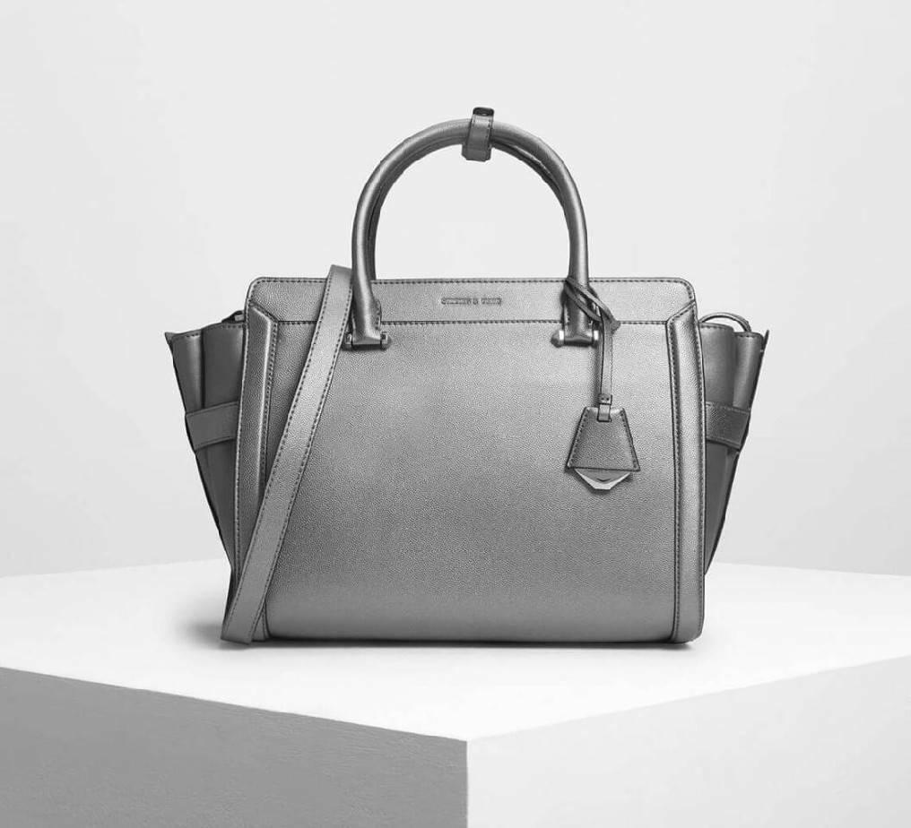 CHARLES & KEITH SAFFIANO TRAPEZE BAG กระเป๋าถือหรือสะพายรุ่นยอดนิยมดีไซน์สวยหรูวัสดุหนังคาเวียร์อยู่ทรง ด้านข้างเเต่งหนังช่องตัดดูมีดีเทล ด้านหน้ามีโลโก้ ด้านหลังมีช่องซิป เปิดปิดด้วยซิปหัวซิปแบรนด์ หูจับเเข็งแรง พับลงได้ พร้อมสายสะพายหนังปรับระดับได้ถอดไ