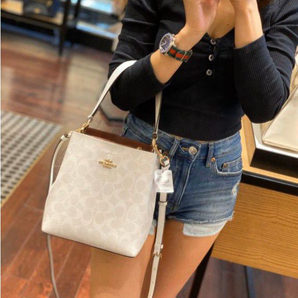 COACH 2312 SMALL TOWN BUCKET BAG IN SIGNATURE CANVAS รุ่นยอดนิยมใบเล็กมาครบสีแล้วจ้า กระเป๋าทรงบัคเก็ต สีผู้ดี๊ผู้ดี ตัวกระเป๋าดีไซน์คลาสสิคลายซี ดูโดดเด่น วัสดุหนังแคนวาสเคลือบลาย สวยคมทุกมุมจริงๆ!! เปิด-ปิดด้วยกระดุมแม่เหล็กทั้ง 2 ฝั่ง ภายในเป็นช่องโล่ง