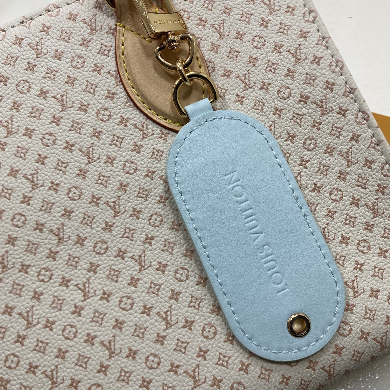 TOP ORI หนังแท้ | LV OnTheGo PM bag Azure Blue/Sand Beige กระเป๋าสะพายทรงโท้ท ในคอลเลกชัน LV Romance หนังแท้หรูหราประดับชาร์มแท็กกระเป๋าเดินทางมีชีวิตชีวา