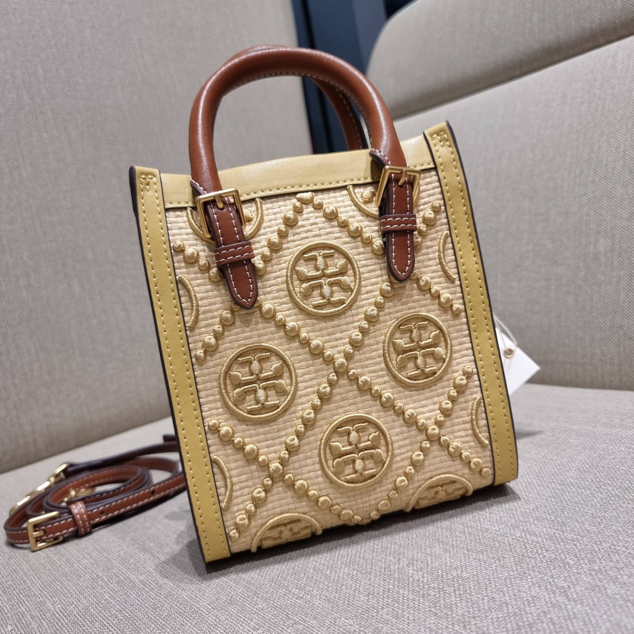 TORY BURCH T MONOGRAM STRAW MINI TOTE สวยสุด ดูแพงสุด!! ต้องยกให้เลย กับไอเท็มนี้ กระเป๋าสะพายทรงโท้ท ไซส์มินิ มีลูกเล่นที่ดีเทลเยอะมาก ด้วยงานฝีมือปักสานด้วยวัสดุจากกธรรมชาติ ถักทอเป็นลายเส้นขึ้นลายนูน ตัดขอบด้วยหนังแท้ และยังโดดเด่นด้วยหูจับในตัวโทนสีอุ