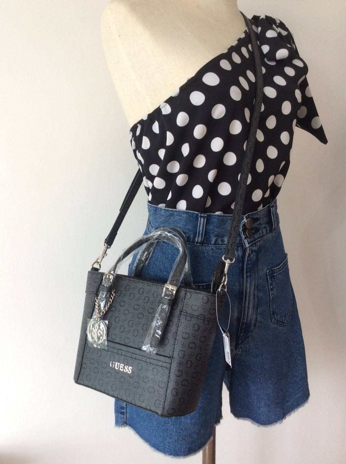 Don’t Miss! GUESS CATE MINI CROSS BODY BAG กระเป๋าถือหรือสะพายรุ่นที่ฮิตและขายดีที่สุดจาก GUESS FACTORY หนัง Saffiano ลาย GUESS Signature สวยอยู่ทรง ขนาดกำลังดี น้ำหนักเบา ด้านหน้าประดับโลโก้พร้อมพวงกุญแจโลโก้แบรนด์ห้อยที่หูกระเป๋าถอดเเยกใช้ได้ เปิดปิดด้ว