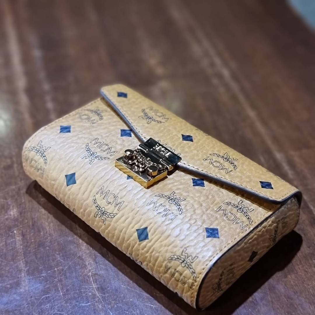 M.C.M SMALL MILLIE FLAP CROSSBODY IN VISETOS ไซส์ใหม่พกพาสะดวก!! กระเป๋าสะพายกึ่งคลัทช์ รอบนี้มาไซส์สวย สามารถใช้แทนกระเป๋าสตางค์ได้เลย ใส่โทรศัพท์มือถือได้ทุกรุ่น ใส่ของสำคัญสบายๆ มาพร้อมสายสะพายโซ่สีทองหรูหรา รูปทรงดีไซน์ร่วมสมัย ใช้งานง่ายด้วยตัวล็อค ว