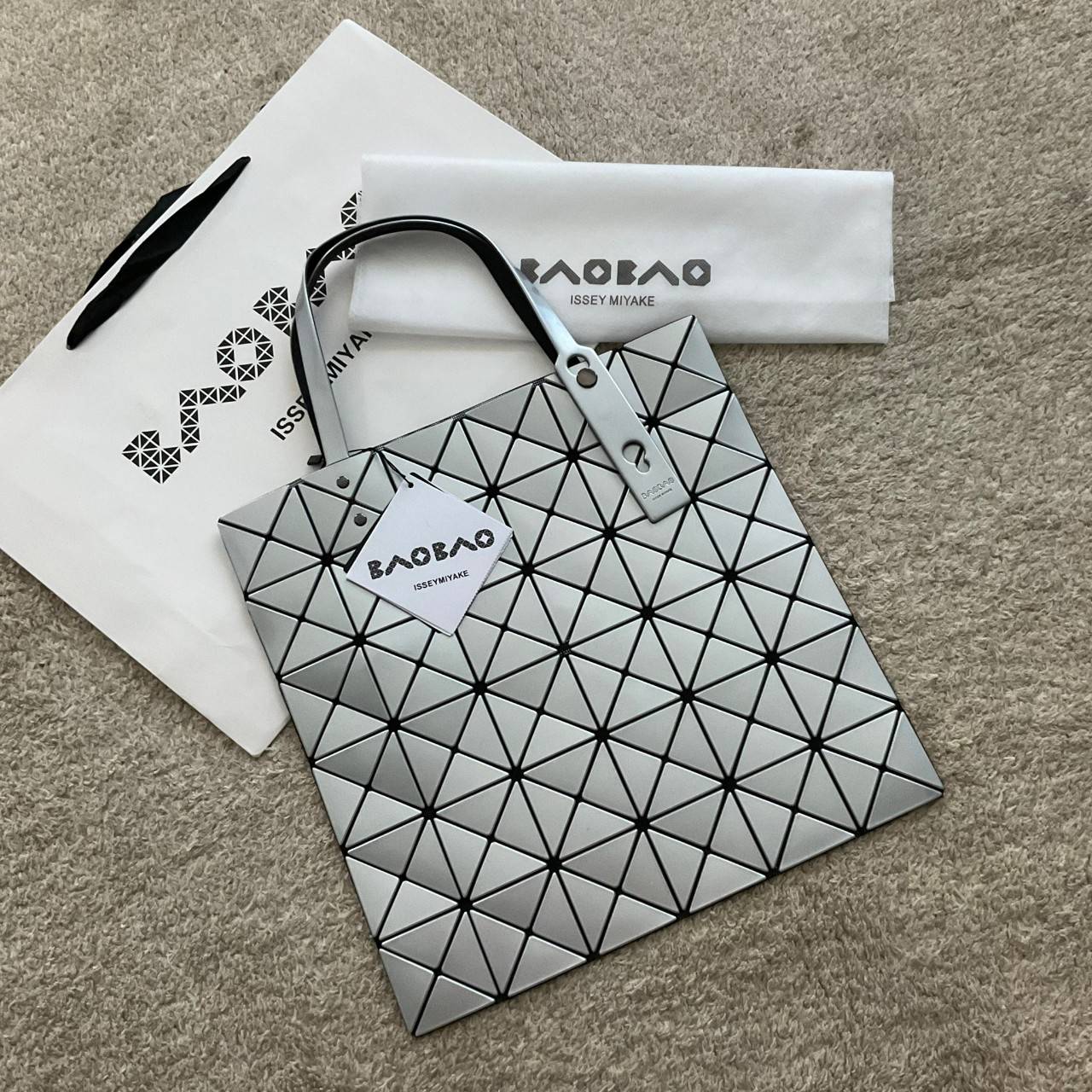BAO BAO ISSEY MIYAKE TOTE BAG (6x6) กระเป๋าสะพายไหล่ ใบใหญ่ ทรงโท้ท จุดเด่นคือ ปรับได้หลายทรงตามเอกลักษณ์เฉพาะของแบรนด์นี้ ด้านในใส่ของได้เยอะมาก ใส่ไอแพด สมุดโน้ตได้สบายเลย พร้อมช่องซิปใส่ของให้อีกหนึ่งช่อง วัยทำงานหรือวัยนักศึกษา อย่างน้อยต้องมีแบรนด์นี