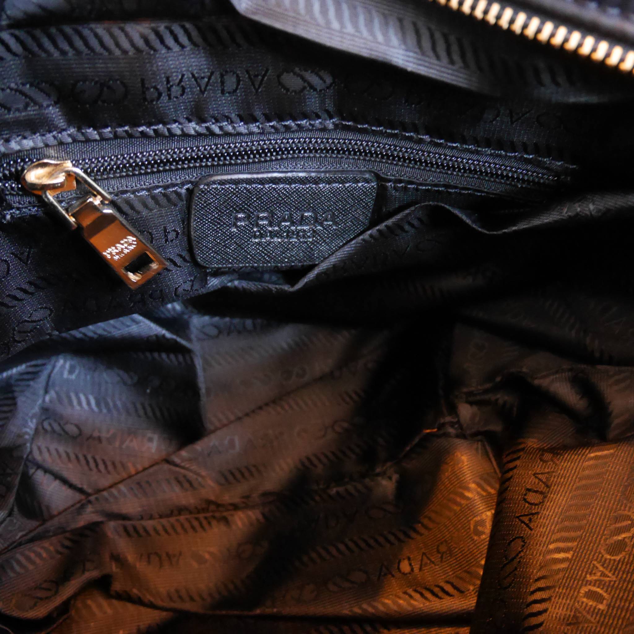 Restock! must have now!! สำหรับกระเป๋าอเนกประสงค์ ทรง **MiniTOTE จากแบรนด์ PRADA เป็น กระเป๋าผ้าไนล่อน ตามแบบฉบับของแบรนด์เลย ใบนี้มีสายยาวให้ค่ะ เลิศมาก สะพายเป็น shoulder bag หรือ ถือได้คะ ด้านหน้าเป็นลายหมี ปั๊กกลิ้ตเตอร์ + logo brand ใช้แล้วสวยมากๆ อะ