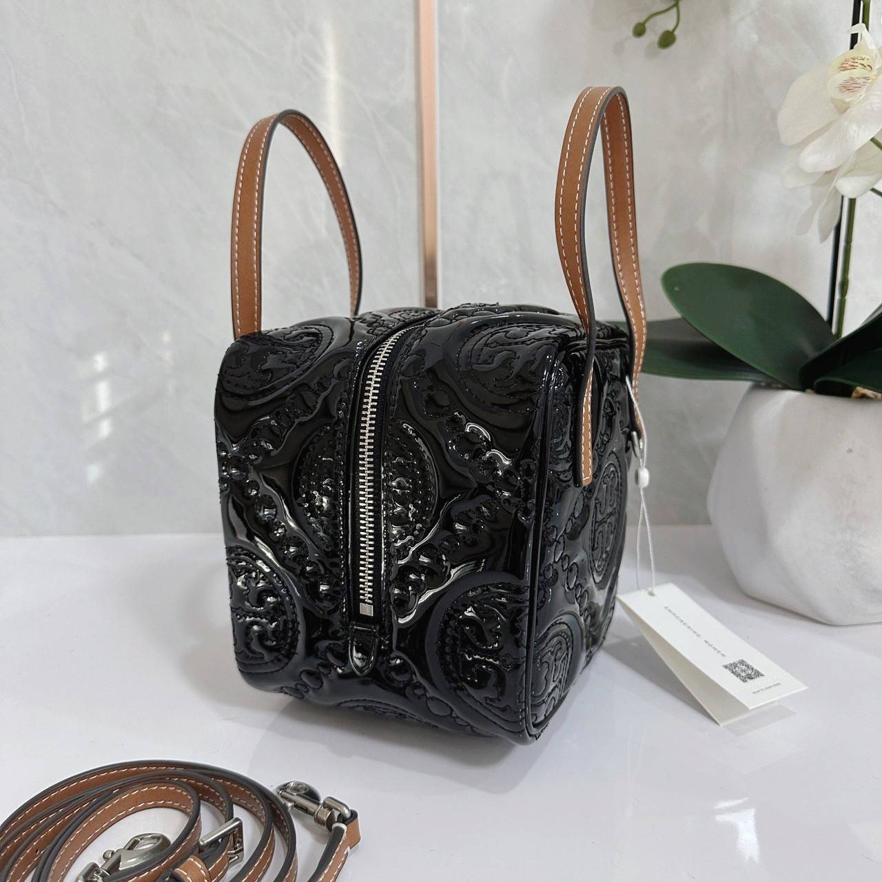 Tory Burch T Monogram Embroidered Patent Cube คอลเลคชั่นใหม่ รุ่นลิมิเต็ดรูปทรงใหม่ T Monogram สุดcube วัสดุหนังแท้ เปิด-ปิดด้วยซิป ภายในกว้าง มีช่องแยก 1 ช่อง สามารถใส่โทรศัพท์มือถือได้ทุกรุ่น สามารถถือหิ้วหรือสะพายได้ สายสามารถถอดและปรับระดับได้คะ