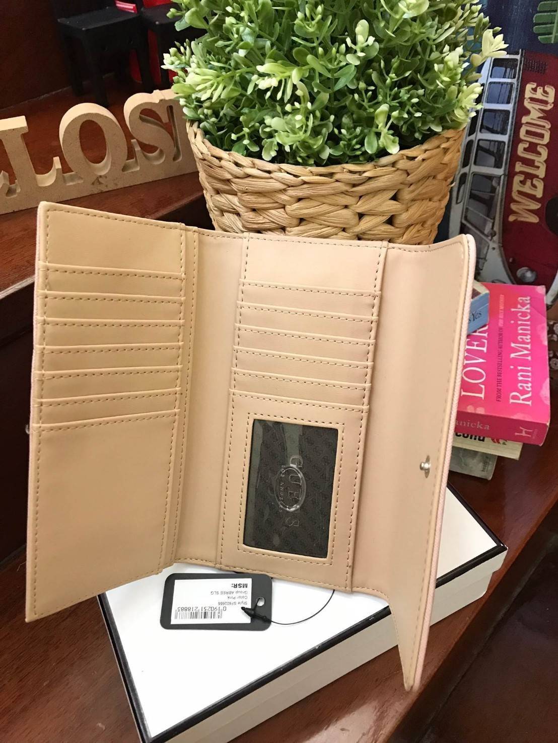 GUESS FACTORY WOMEN'S LONG WALLET กระเป๋าสตางค์ทรงยาวแบบสามพับ วัสดุหนังลายsaffiano เปิดปิดด้วยกระดุมสะดวกใช้ ภายในมีทั้งช่องซิปใส่เหรียญ ช่องใส่ธนบัตรและช่องใส่บัตรหลายช่องและช่องใส่รูปแยกเป็นสัดส่วน ด้านหน้ามีโลโก้แบรนด์ทรงสามเหลี่ยม ด้านหลังมี1ช่อ