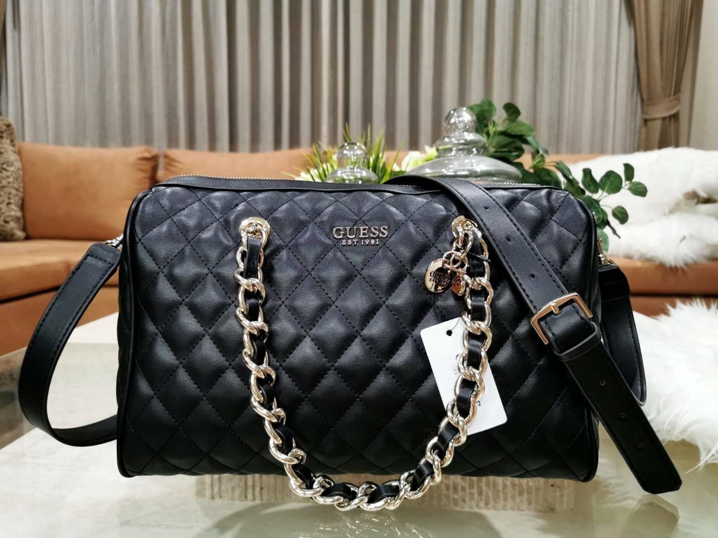 GUESS WOMEN’S BOWLING BAG กระเป๋าสะพายทรง Bowling รุ่นใหม่ล่าสุดจาก GUESS FACTORY หนังนิ่มลายตารางสวยอยู่ทรงใบใหญ่กำลังดี ด้านหน้าประดับโลโก้หูหิ้วโซ่ร้อยหนังสะพายไหล่ได้เเข็งแรงรับน้ำหนักได้เยอะ เปิดปิดด้วยซิปสะดวกใช้ มีหมุดรองฐานกันรอย ภายในมีช่องซิปและ