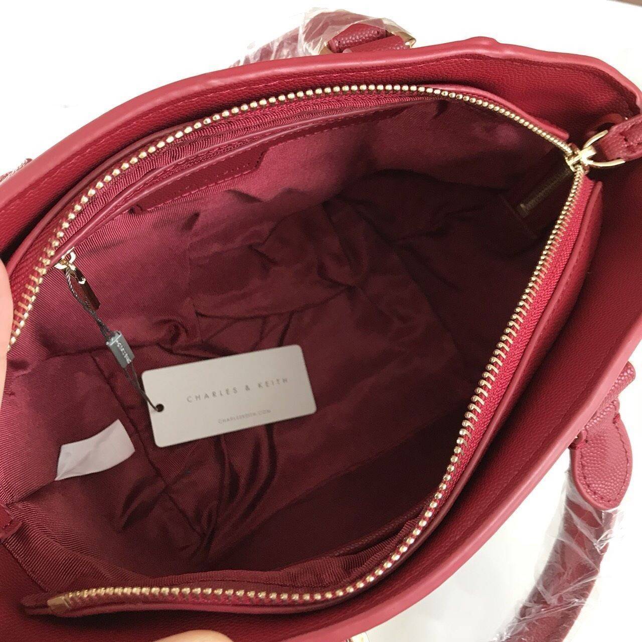 CHARLES & KEITH CITY BAG กระเป๋าถือหรือสะพาย ตั้งอยู่ทรงสวย มีโลหะรองฐาน เปิดปิดด้วยซิปเดียว ภายในมี 2 ช่องเล็กด้านหน้าประดับด้วยกระจกทรงกลม ใช้งานได้จริง ปั้มโลโก้แบรนด์ มาพร้อมสายสะพายยาว ปรับระดับและถอดสายได้ หูพับลงได้ น้ำหนักเบา ต้องมีไว้ครอบครองสักใ