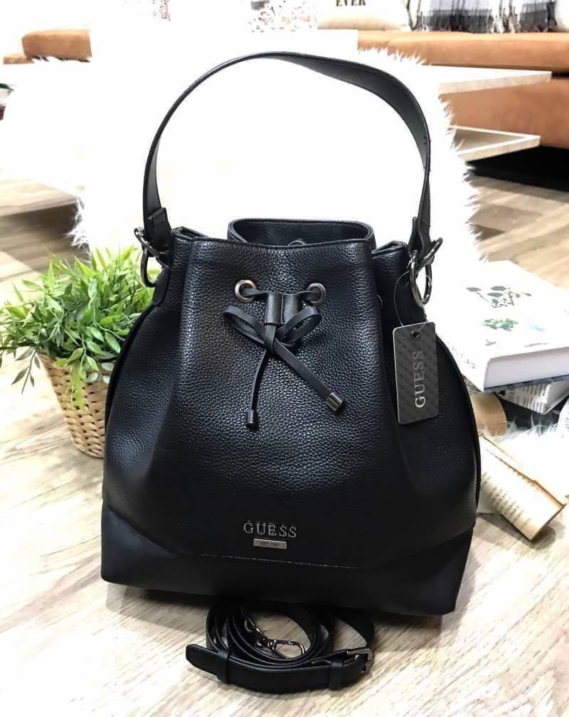 GUESS. DRAWSTRING BUCKET BAG WITH STRAP กระเป๋าถือหรือสะพายแบรนด์ดังรุ่นยอดนิยม วัสดุหนังแกะสังเคราะห์แบบนิ่มสวยอยู่ทรง ด้านหน้าประดับโลโก้ เปิดปิดแบบ Drawstring มาพร้อมสายสะพาย 2แบบ ทั้งสายสั้นสะพายไหล่และสายยาว crossbody ปรับระดับได้ ภายในกว้างมีช่องซิป