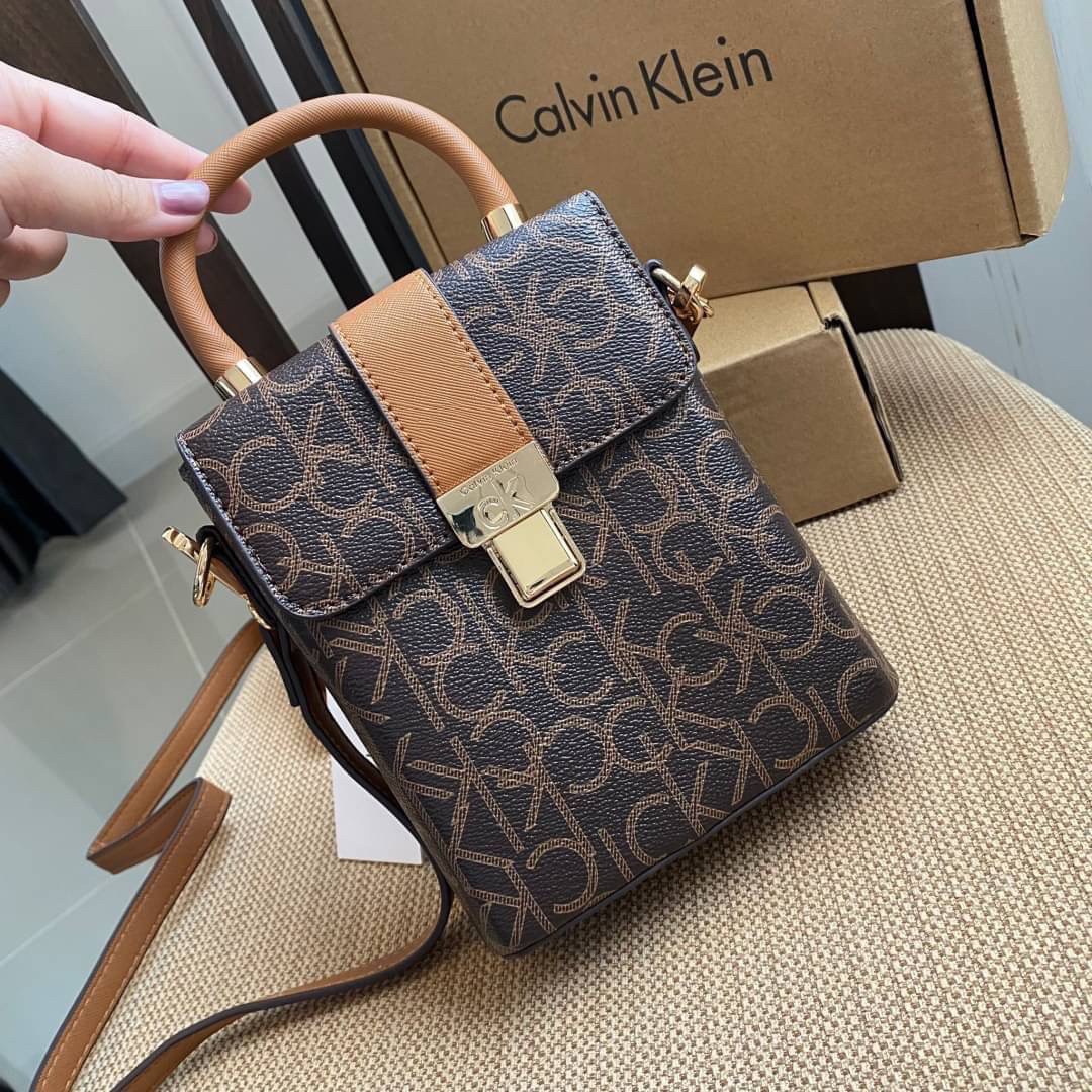 CALVIN KLEIN JEANS crossbody bag กระเป๋าถือหรือสะพาย ลายซิกเนเจอร์แบรนด์ทั้งใบ มีหูจับสำหรับถือ เปิด-ปิดกระเป๋าด้วยกระดุมแม่เหล็ก ด้านในโล่งกว้างมีช่องเล็กและช่องซิปสำหรับใส่ของจุกจิก ซับในลายแบรนด์อย่างดี มาพร้อมสายสะพายยาวปรับระดับได้ สามารถใช้ได้หลากหล