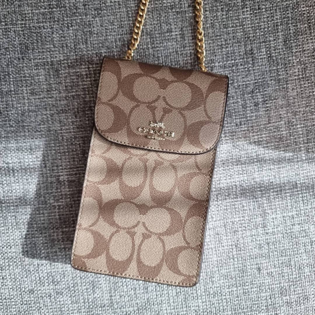 COACH NORTH/SOUTH PHONE CROSSBODY IN SIGNATURE CANVAS F55636 F39955 สุดคลาสสิคกับกระเป๋าสะพายเอนกประสงค์ Case phone ใส่โทรศัพท์มือถือได้ทุกรุ่น ดีไซน์ลายเอกลักษณ์ วัสดุหนังแคนวาสเคลือบลาย ฝาและภายในเป็นหนังสังเคราะห์เรียบ เปิด-ปิดด้วยกระดุม สายสะพายยาวประ