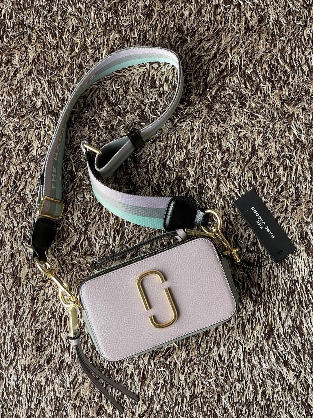 Marc Jacobs Snapshot Bag กระเป๋าแบรนด์ดังจากสัญชาติอเมริกัน นับได้ว่ารุ่นนี้เป็นรุ่นทรงฮิตเลยทีเดียว โดยด้านหน้ากระเป๋าจะเป็นโลโก้แบบโลหะที่เป็นสัญลักษณ์ของแบรนด์นี้ มาพร้อมสายสะพายที่จะสะพายยังไงก็ดูโดดเด่น เพราะขนาดใหญ่ที่สกรีนตัวอักษรโลโก้ ในรูปแบบต่าง