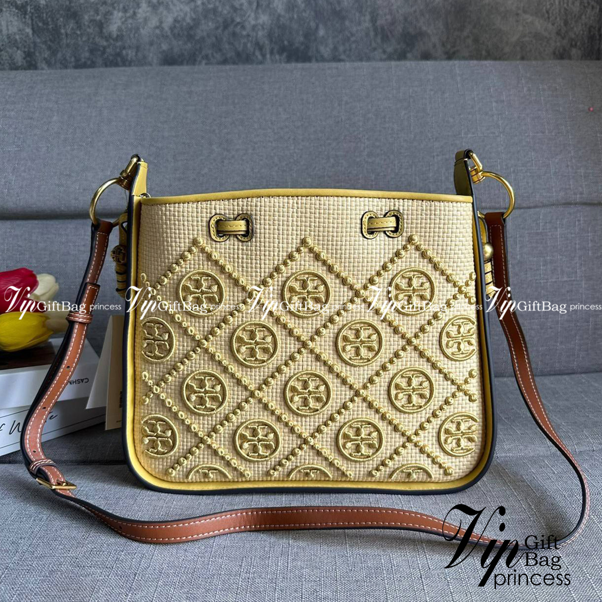 TORY BURCH T Monogram Straw Bell Bag กระเป๋าสะพายข้างรุ่นคลาสสิกที่ได้แรงบันดาลใจจากการควิลท์แบบดั้งเดิมของเพนซิลเวเนีย คอลเลกชันบ่งบอกถึงความมีสไตล์เหนือกาลเวลา รูปทรงเรียวโดดเด่น ปักทอลายแบรนด์อย่างสวยงาม เปิด ปิดด้วยเชือกรูด ด้านในช่องโล่งกว้าง ซับในผ้