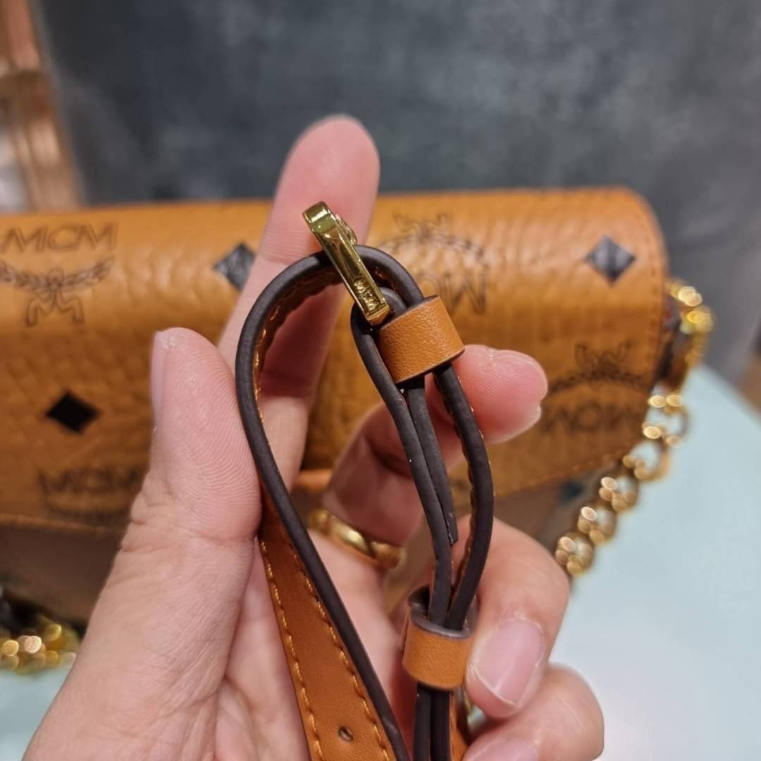 M.C.M MINI PATRICIA CROSSBODY IN VISETOS กระเป๋าสะพายไซส์มินิ แรงดีไม่มีตกน้า คอลเลคชั่นนี้ดีไซน์แปลกใหม่ ทรงโค้งมน สวยหรู ด้านข้างตกแต่งหมุดทองรอบใบ วัสดุตัวกระเป๋าเป็นหนังแคนวาสคุณภาพดี ภายในเป็นหนังกลับสีส้มโดดเด่นเป็นเอกลักษณ์ มีช่องใส่บัตรแยกให้ เปิด