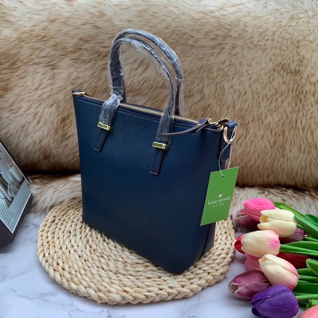 ของแท้ 💯% Kate Spade New York Cross Body Bag กระเป๋าถือหรือสะพาย หนัง Saffiano ภายในมีช่องซิปและช่องเล็ก มีหมุดรองฐานกันรอย 4 มุม อะไหล่ทองทั้งใบ ขนาดกำลังดี ใส่กระเป๋าสตางค์ยาวได้ค่ะ