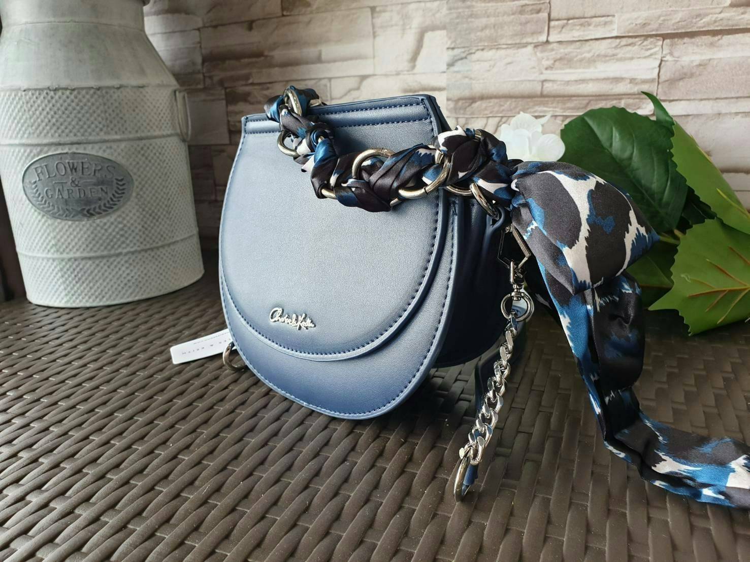 CHARLES & KEITH รุ่น LEATHER SATIN SCARF CROSSBODY BAG SL2-50150828 ราคาปกติช้อป ( ฿3,590.00 ) กระเป๋าถือ และ สะพาย ทรงโค้งมน หนังเรียบ ตั้งอยู่ทรง ด้านหน้าติดโลโก้แบรนด์ อะไหล่เงิน หูจับสายกระเป๋าร้อยเข้ากับห่วงเหล็กกลมๆ ด้วยผ้าลายสวยงามผูกเป็นโบว์เก๋ๆ ถ