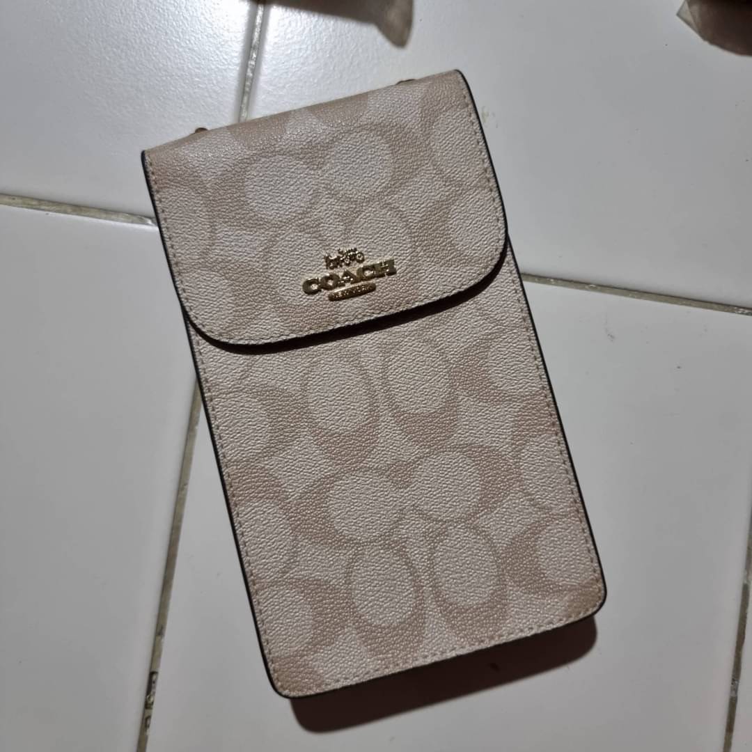 COACH NORTH/SOUTH PHONE CROSSBODY IN SIGNATURE CANVAS F55636 F39955 สุดคลาสสิคกับกระเป๋าสะพายเอนกประสงค์ Case phone ใส่โทรศัพท์มือถือได้ทุกรุ่น ดีไซน์ลายเอกลักษณ์ วัสดุหนังแคนวาสเคลือบลาย ฝาและภายในเป็นหนังสังเคราะห์เรียบ เปิด-ปิดด้วยกระดุม สายสะพายยาวประ