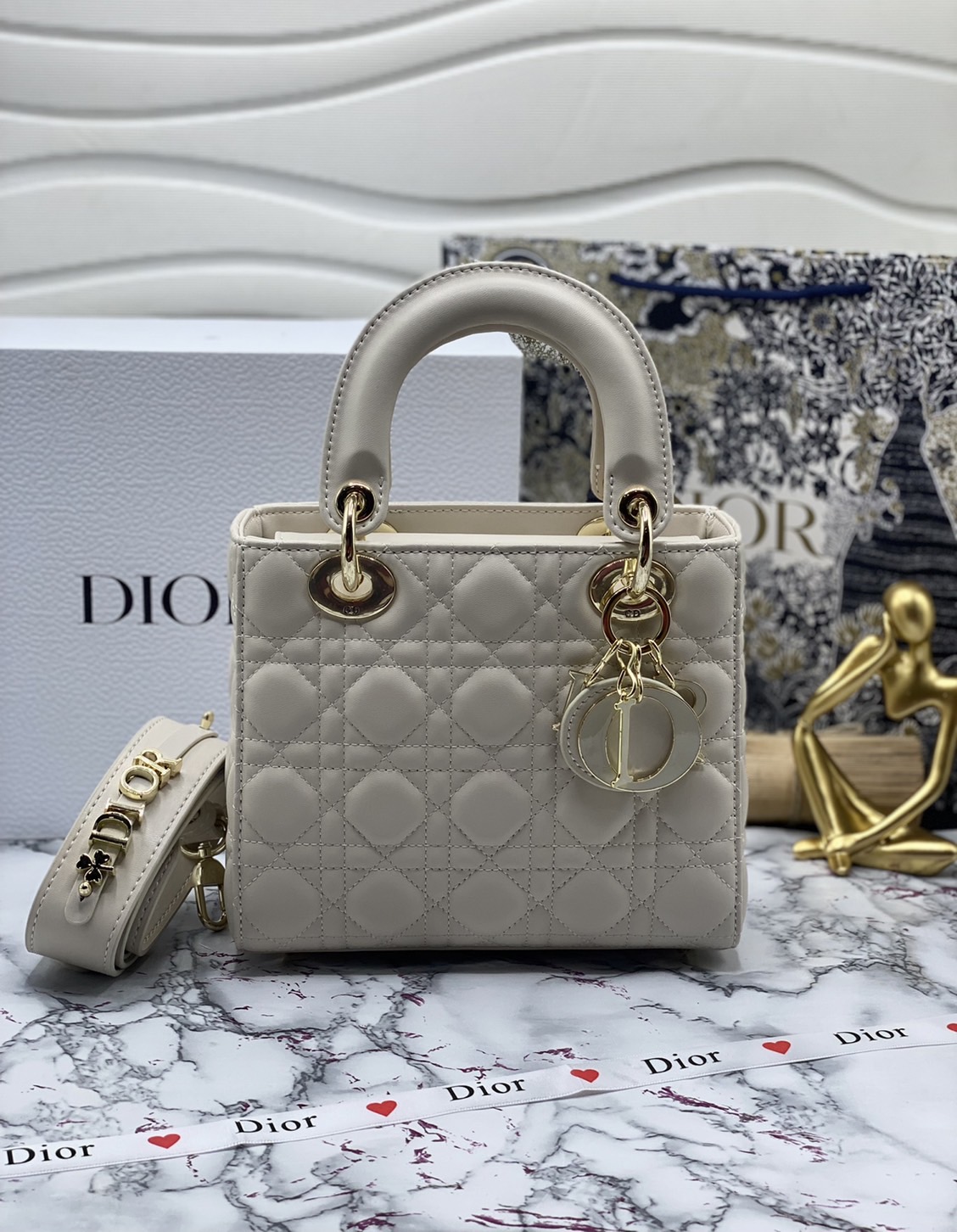 หนังแท้ DIOR LADY BAG 20cm ความสง่างามอีกหนึ่งรุ่นของ Dior รูปทรงสีเหลียม ขนาดกระทัดรัด ตั้งอยู่ทรง ฐานกระเป๋าแข็งแรง มีหมุดรองฐาน ดีไซน์ที่มีเอกลักษณ์เฉพาะตัว ด้านหน้าตกแต่งด้วยตัวอักษร D.I.R ห้อยเป็นพวงกุญแจ จะถือด้วยมือหรือสะพายไหล่ก็ดูดีมากๆ ค่ะ