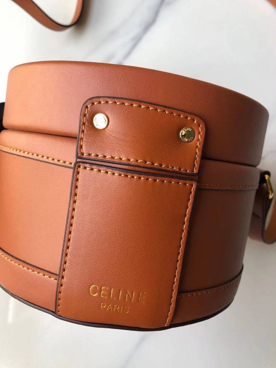 CELINE MEDIUM TAMBOUR IN SMOOTH CALFSKIN BAG กระเป๋าทรงกลมสวยหรูอยู่ทรงเปิดปิดด้วยฝาปิดกระดุมโลโก้แบรนด์ ภายในโล่ง