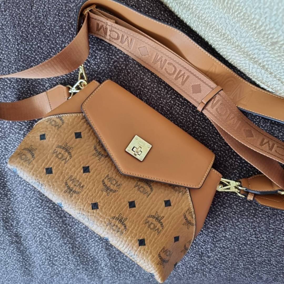 M.C.M ESSENTIAL CROSSBODY IN VISETOS กระเป๋าสะพายข้าง สวยอยู่ทรง ดีไซน์ไม่ซ้ำใคร มาพร้อมสายสะพายถึง 2 แบบ ปรับเปลี่ยนใช้ได้ไม่มีเบื่อ วัสดุหนังแคนวาสสลับหนังแท้ เปิด-ปิดกระเป๋าด้วยตัวบิดล็อคแน่นหนา ด้านหลังมีช่องเก็บบัตรได้ ภายในโล่งกว้าง แบ่งสัดส่วน เป็น