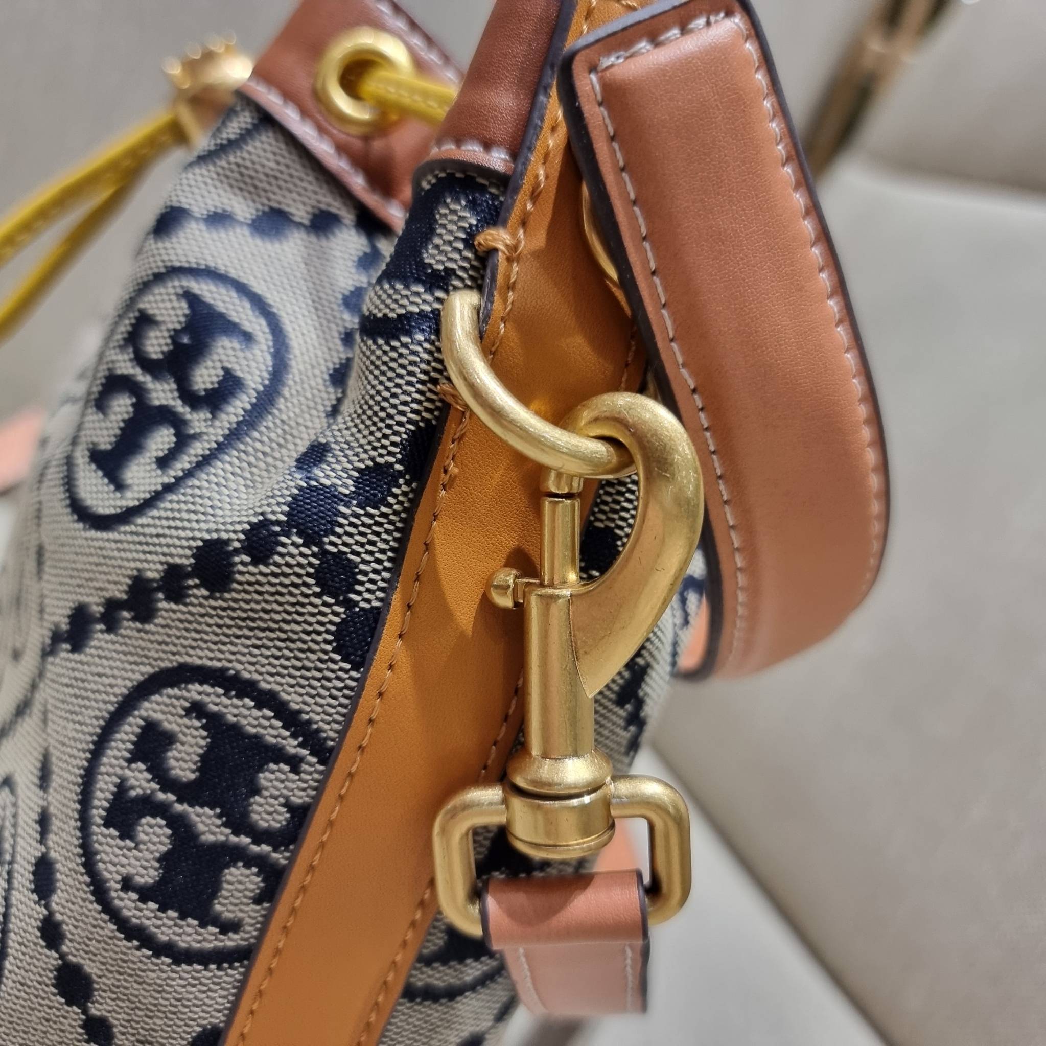 TORY BURCH T MONOGRAM COLORBLOCK JACQUARD BUCKET BAG ไอเท็มใหม่ที่ใครๆก็รอ กระเป๋าบัคเก็ตทรงสวย ที่ยังคงให้ความโดดเด่นด้วยลวดลายเอกลักษณ์ เพิ่มเติมดีไซน์บล็อคสี ตัดกันได้อย่างลงตัว ถักทอบนวัสดุ woven jacquard ลายคมชัด สลับส่วนของหนังแท้ ภายในเป็นช่องโล่งก