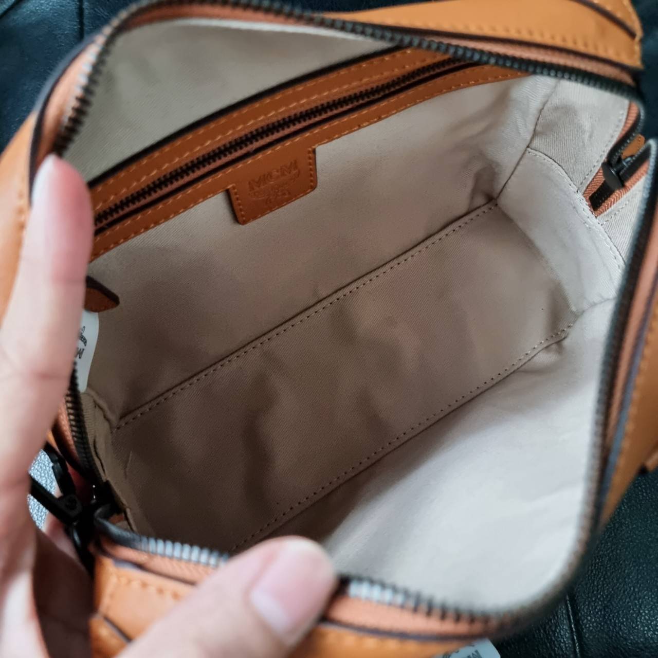 M.C.M SMALL E/W SOFT BERLIN CROSSBODY IN VISETOS ไอเท็มใหม่ในดีไซน์ทรงกระเป๋าเดินทางแบบคลาสสิค ย่อส่วนมาให้ใช้งานได้แบบสบายๆ พกพาสะดวก แมทช์ได้ทุกสไตล์ ใช้ได้แบบ unisex ใช้งานง่ายด้วยหูจับในตัว และซิปหลัก อะไหล่สีดำดูมีมิติตัดกับสีน้ำตาลคอนยัคได้เป็นอย่าง