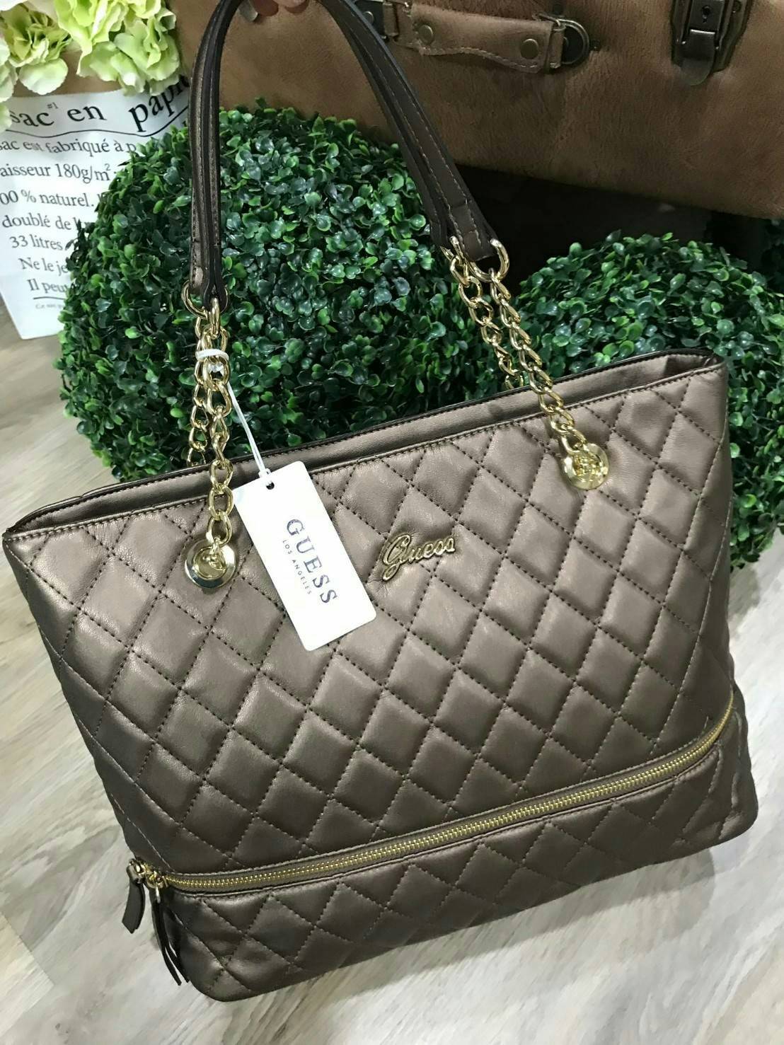 GUESS WOMEN’S SHOPPER BAG WITH ZIPS (SIZE L) กระเป๋าสะพายรุ่นใหม่ล่าสุดจาก GUESS FACTORY ลายตารางข้าวหลามตัดหนังนิ่มสวยอยู่ทรงไม่ย้วยขนาดใหญ่กำลังดี ด้านหน้าประดับโลโก้ พร้อมแต่งซิปดูมีดีเทล หูหิ้วสะพายไหล่โซ่ต่อหนังเเข็งแรงรับน้ำหนักได้เยอะ เปิดปิดด้วยซิ