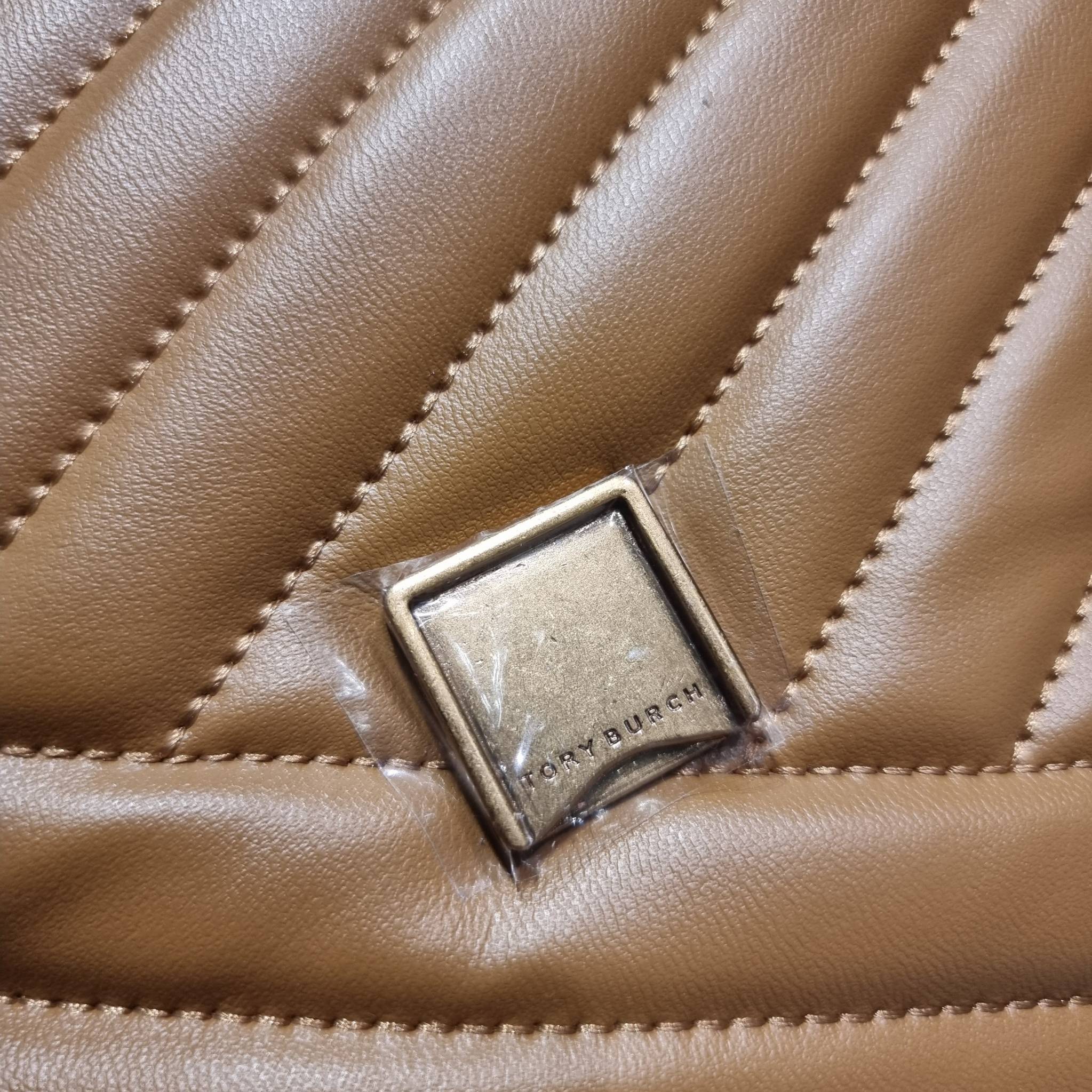 TORY BURCH KIRA CHEVRON CONVERTIBLE SHOULDER BAG กระเป๋าสะพายรุ่นยอดฮิต ไซส์ใหญ่จัดเต็มให้เน้นๆ ใช้ยังไงก็ดูหรู ดีไซน์เฉพาะตัว วัสดุหนังแกะ สัมผัสนิ่ม เปิด-ปิดด้วยกระดุมแม่เหล็ก ภายในเป็นช่องโล่ง แบ่งสัดส่วนไว้ดีมากๆ ใส่กระเป๋าสตางค์ มือถือ เครื่องสำอางค์