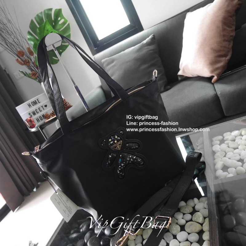เอาใจคนชอบกระเป๋าไซส์กลาง *มาพร้อมสายยาว สำหรับกระเป๋าอเนกประสงค์ ทรง TOTE จากแบรนด์ PRADA เป็น กระเป๋าผ้าไนล่อน ตามแบบฉบับของแบรนด์เลย ใบนี้มีสายยาวให้ค่ะ เลิศมาก สะพายเป็น shoulder bag หรือ ถือได้คะ ด้านหน้าเป็นลายหมี ปั๊กกลิ้ตเตอร์ + logo brand ใช้แล้ว