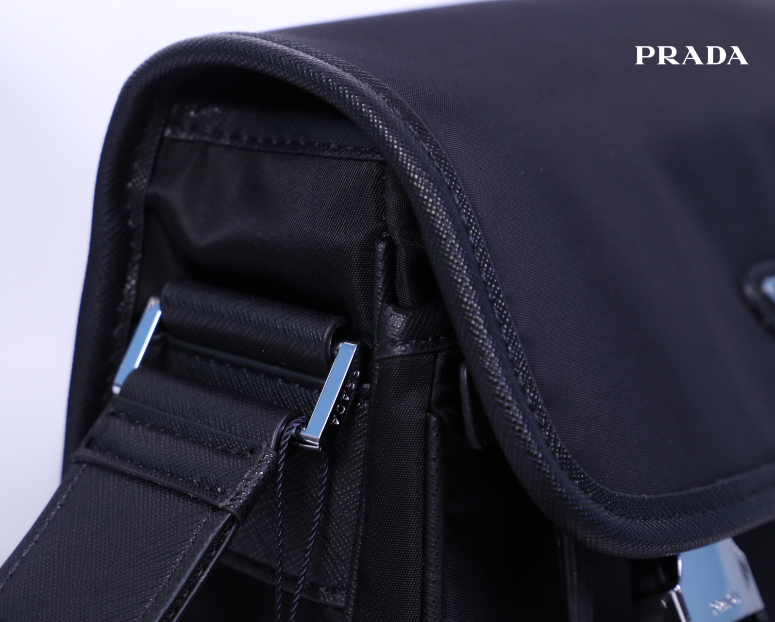 Prada Nylon and Saffiano Leather Bag with Strap กระเป๋าสะพายแบบ Crossbody ใช้ได้ทั้งหญิงชาย มาพร้อมกระเป๋าใส่เหรียญใบเล็กน่ารัก เปิด-ปิดด้วยตัวล็อค ด้านในยังแบ่งช่องเป็นสัดส่วน จุของได้เยอะ ซับในด้วยผ้าพิมพ์ลายแบรนด์อย่างดี และยังมี 1 ช่องซิปด้านหลัง สายส