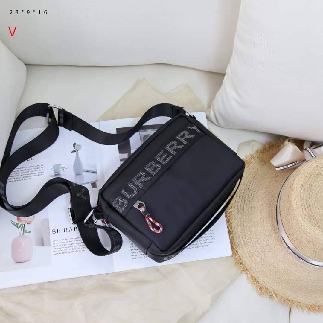 BURBERRY FRAGRANCES CROSSBODY BAG / BURBERRY Nylon Crossbody Bag วัสดุ Nylon Canvas ทรงเหลี่ยมน้ำหนักเบามีโลโก้แบรนด์คาดด้านหน้าพร้อมช่องซิปใส่ของ เปิดปิดด้วยซิปหัวซิปแบรนด์สไตล์สปอร์ต ภายในมีช่องใส่บัตร ขนาดกำลังดีสามารถใส่กล้อง มือถือ กระเป๋าสตางค์ของใช
