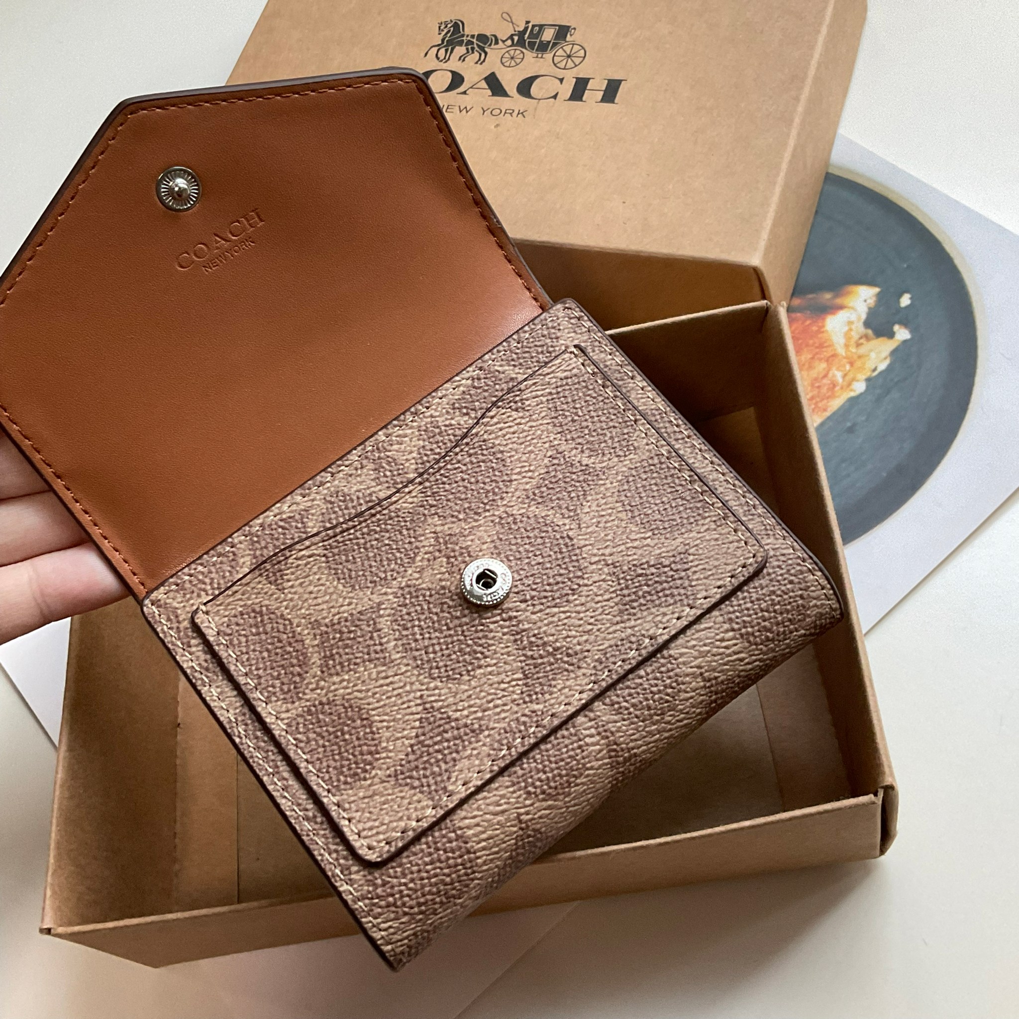 COACH SMALL WALLET IN SIGNATURE CANVAS กระเป๋าสตางค์ใบสั้น แบบพับสองตอน หน้าจดหมาย เปิดปิดด้วยกระดุมปั้มแบรนด์ ด้านในมีช่องใส่บัตรหลายช่อง และช่องใส่ธนบัตร ด้านหลังมีช่องซิปเหรียญอีกหนึ่งช่อง น้ำหนักเบา พกพาสะดวก มีให้เลือกหลายสี ห้ามพลาดค่ะ!