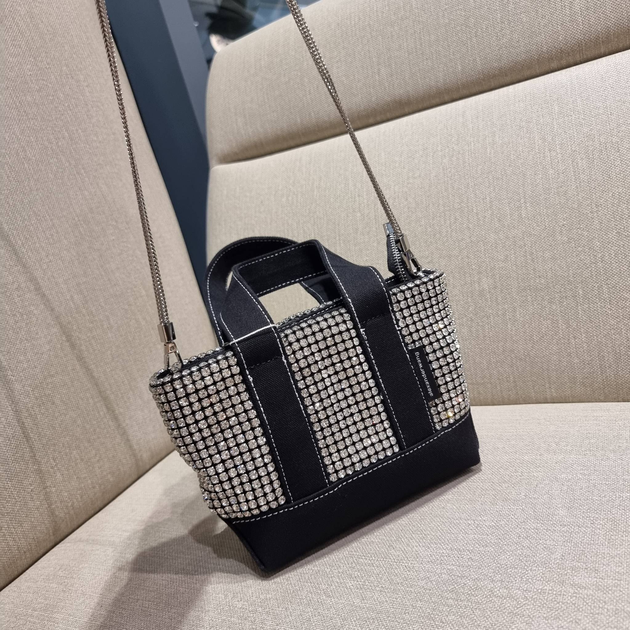 ALEXANDER WANG HANDBAG MINI TOTE WITH RHINESTONE กระเป๋าทรงมินิโท้ท น่ารักน่าเอ็นดู น่าใช้เหลือเกิน!! ด้วยความโดดเด่นเด่นของการตกแต่งพลอยเทียม ให้ดีเทลหรู ตัดสลับด้วยผ้าแคนวาส เพิ่มความทนทาน ลงตัวมากๆ และยังใช้งานง่ายด้วยหูจับในตัว เปิด-ปิดด้วยซิป ภายในเป