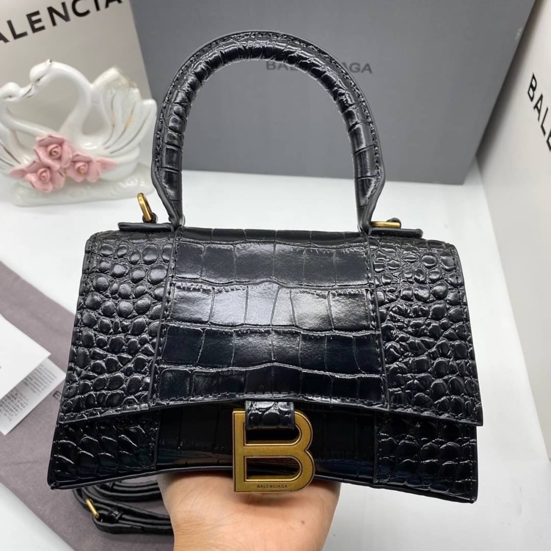 หนังแท้ BALENCIAGA HOURGLASS TOP HANDLE XS Shiny crocodile embossed calfskin การสร้างสรรค์ที่มีเอกลักษณ์เฉพาะตัว หรูหรา โทนสีโดดเด่น วัสดุหนังแท้ลายจระเข้ ภายในโล่งกว้างหนังแนปป้าอย่างดี เกรดออริจินอล ตอบโจทย์ได้ทุกลุค ทุกไลฟ์สไตล์ ภาพสินค้าถ่ายจากงานขายจ