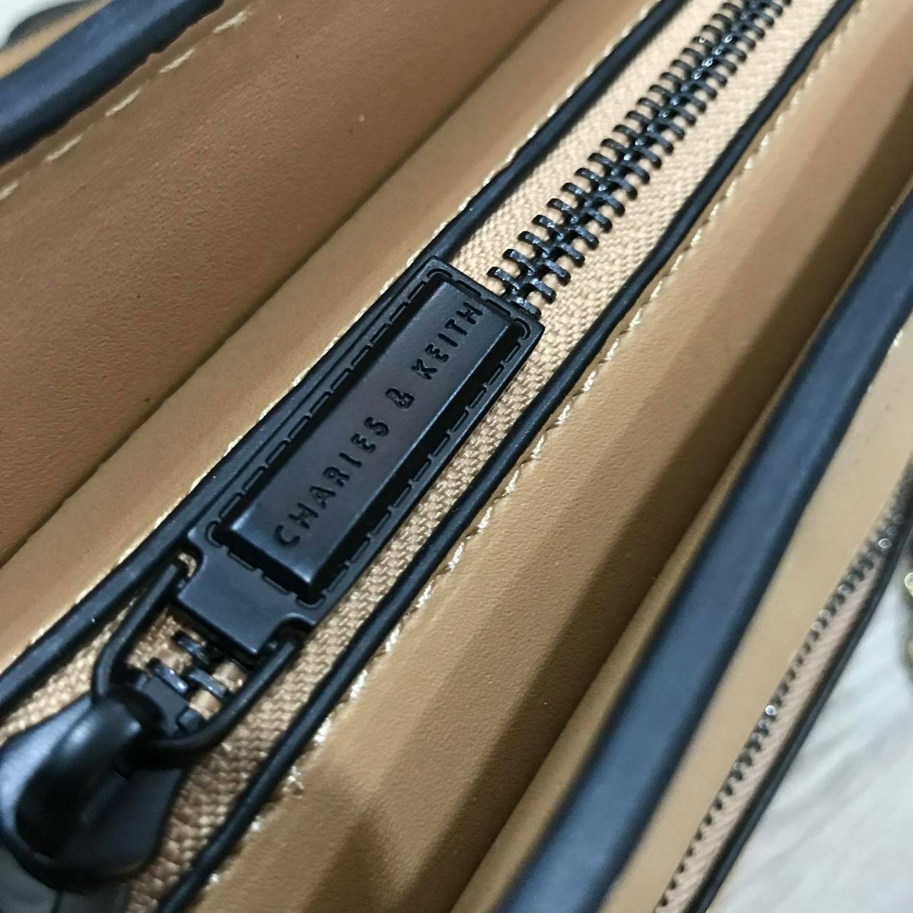 CHARLES & KEITH TRAPEZE CROSSBODY BAG กระเป๋าถือหรือสะพายดีไซน์ยอดนิยมหนังอยู่ทรงสวย ด้านหน้าสกรีนโลโก้ และมี 1 ช่องซิป เปิดปิดด้วยซิป ภายในมีช่องใส่ของ และช่องซิปเล็ก ใส่กระเป๋าสตางค์ใบยาว มือถือ ของใช้ได้เยอะ พร้อมสายสะพายยาวโซ่ต่อหนังปรับได้ถอดได้ มีหม