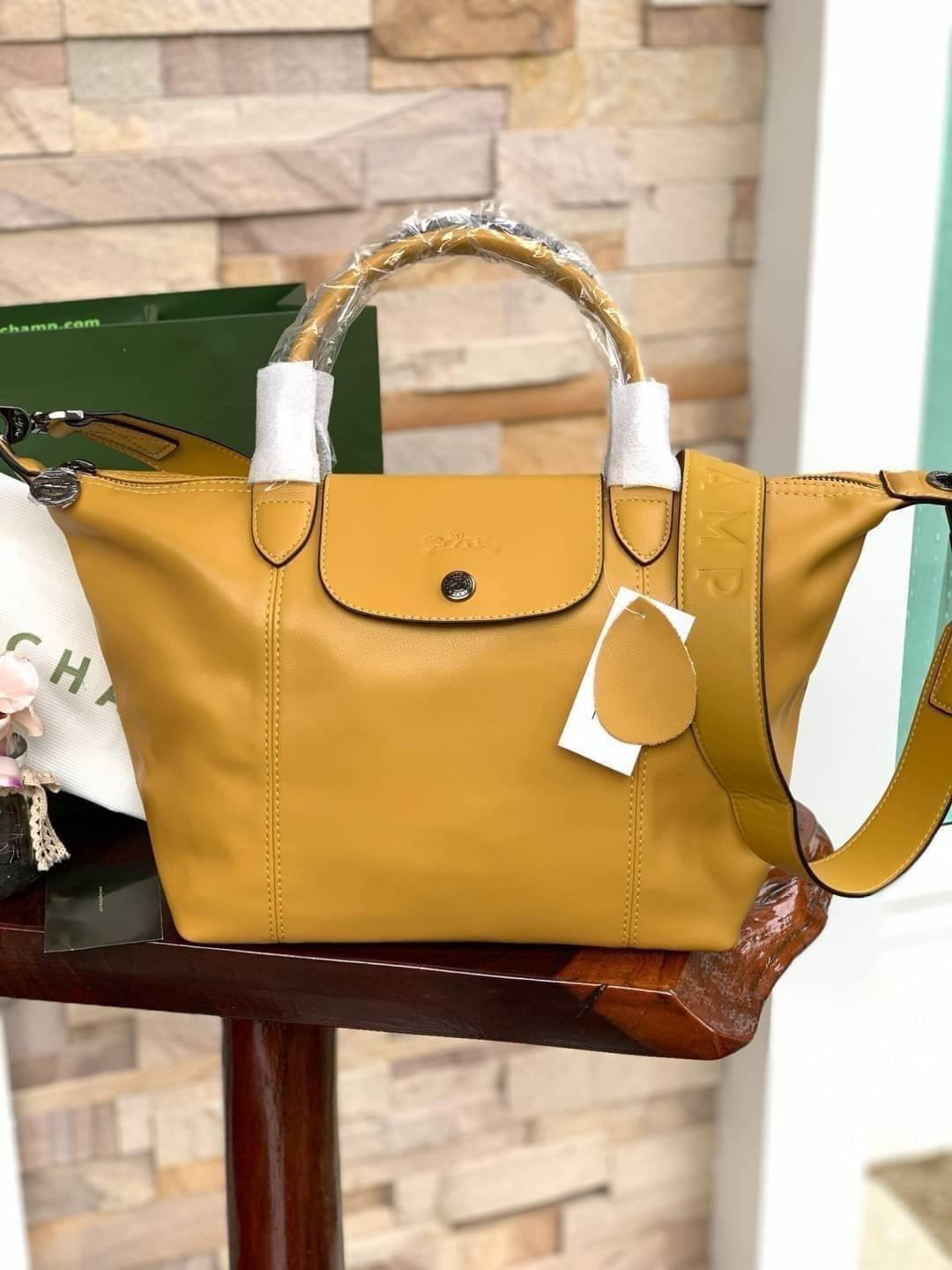 Longchamp LE PLIAGE CUIR TOP HANDLE BAG S เรียกว่าเป็นกระเป๋าอีกหนึ่งรุ่นที่ไม่ว่ายังไงก็ฮอตฮิตและติดเทรนด์ตลอดไม่เคยเปลี่ยนกับ ทรง Le Pliage Cuir หนึ่งในตระกูลกระเป๋าสุดไอคอนิกจากแบรนด์ เมื่อรุ่น Le Pliage Cuir ในรูปแบบของหนังแกะ Metis ได้ถือกำเนิดขึ้นใน