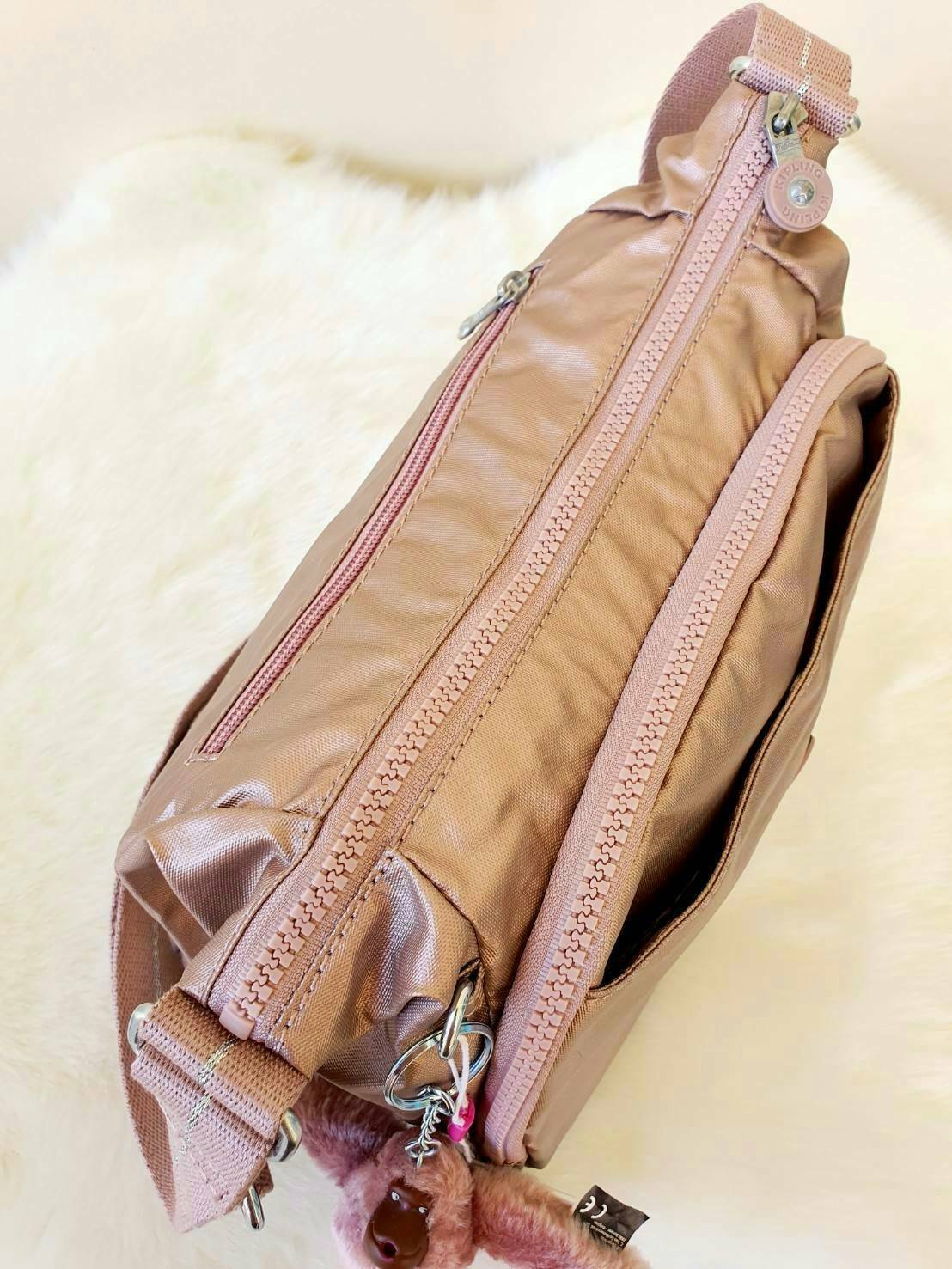 KIPLING CAI (K12587) กระเป๋าสะพายสีชมพูสดใส มาพร้อมกับพวงกุญแจลิงสีกุหลาบเข้ากับสีกระเป๋าสวยน่าใช้มากๆค่ะ ตัวกระเป๋าเปิดปิดด้วยซิปเป็นหลัก มีหลายช่องซิปแบ่งใส่ของได้เป็นสัดส่วน ภายในโล่งกว้าง สามารถใส่กระเป๋าสตางค์ใบยาวและมือถือได้ทุกรุ่น สายสะพายปรับสั้น