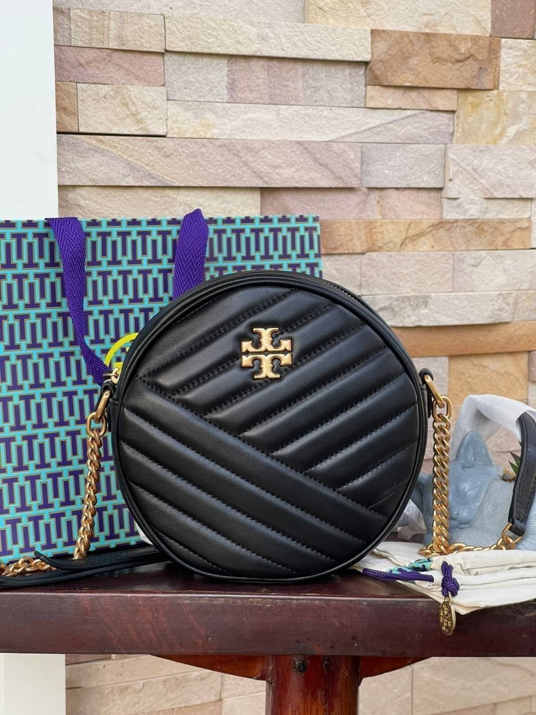 Tory burch Kira Cheron Circle Crossbody กระเป๋าสะพายคาดลำตัวรุ่นนี้โดดเด่นด้วยรูปทรงกลมสุดชิค ขนาดกะทัดรัด พร้อมด้วยหนังกระเป๋าที่ทำจากหนังแท้คุณภาพดี เพราะ Kira Chevron เป็นรุ่นที่ตอบโจทย์และครองใจสาว ๆ ได้อย่างแท้จริง เนื่องจากมีดีไซน์เรียบหรู โดยทางแบร