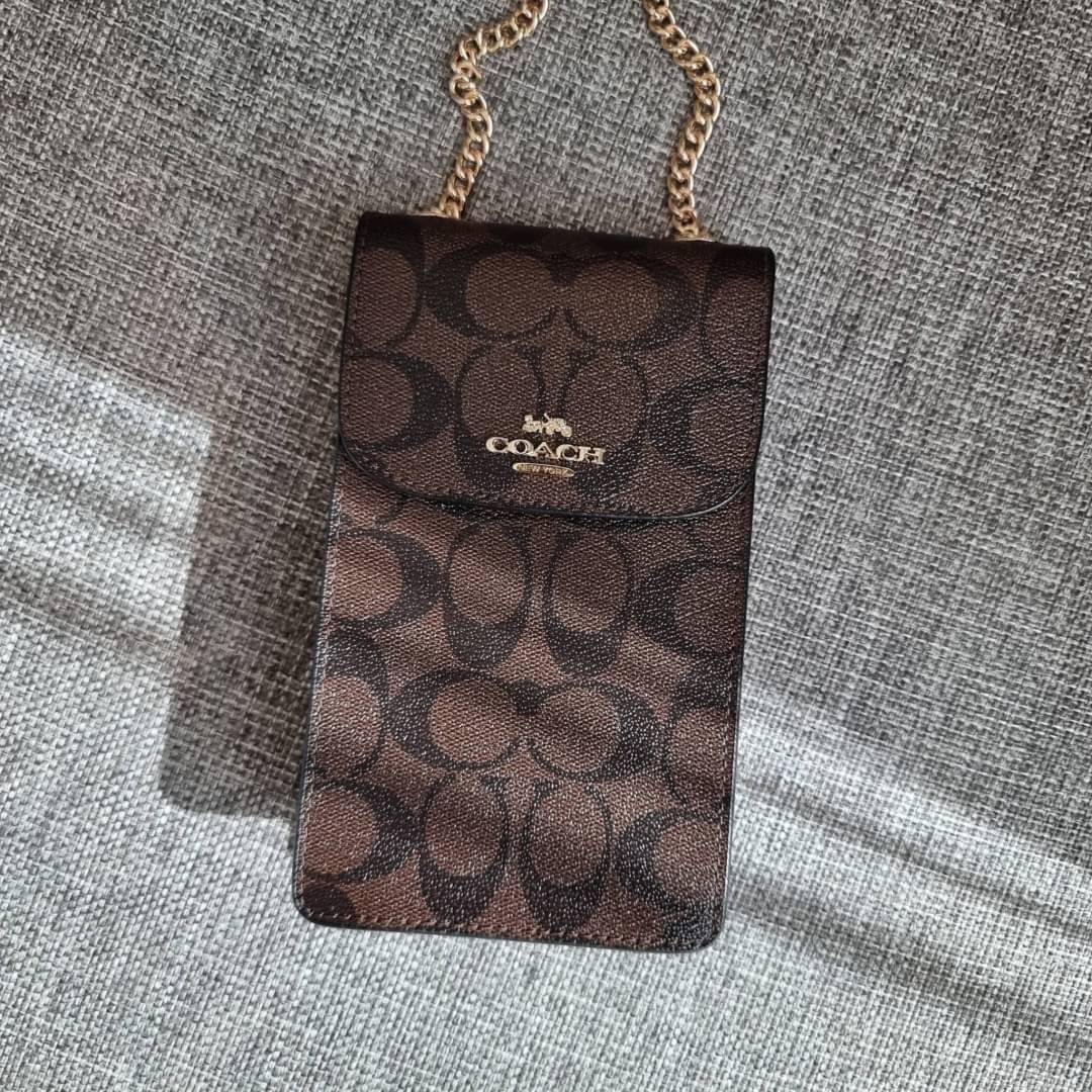 COACH NORTH/SOUTH PHONE CROSSBODY IN SIGNATURE CANVAS F55636 F39955 สุดคลาสสิคกับกระเป๋าสะพายเอนกประสงค์ Case phone ใส่โทรศัพท์มือถือได้ทุกรุ่น ดีไซน์ลายเอกลักษณ์ วัสดุหนังแคนวาสเคลือบลาย ฝาและภายในเป็นหนังสังเคราะห์เรียบ เปิด-ปิดด้วยกระดุม สายสะพายยาวประ