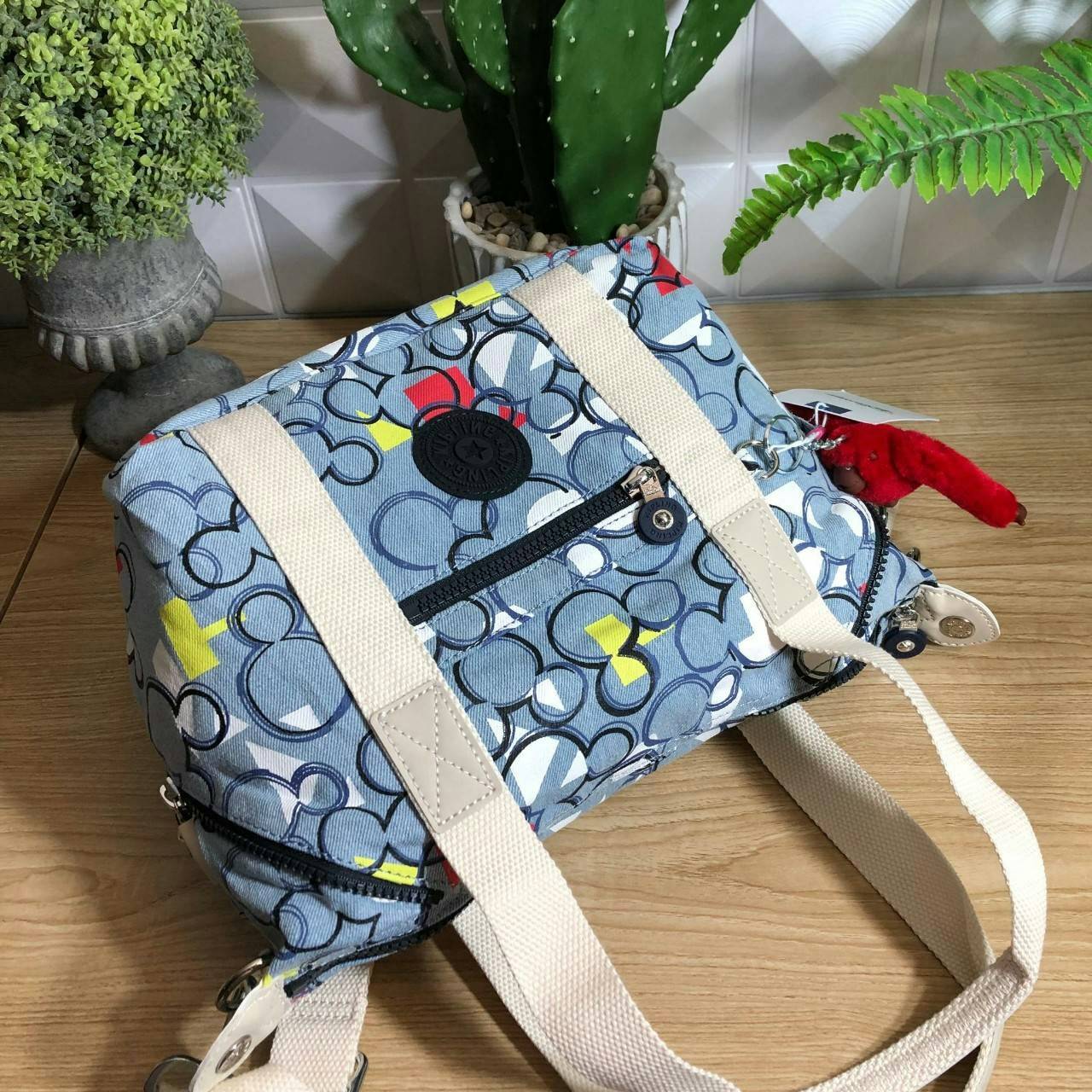 Kipling D ART MINI Collection Mickey กระเป๋าถืออเนกประสงค์ Art Mini จาก KIPLING ขนาดเล็กมีน้ำหนักเบา และช่องกระเป๋ากว้าง สะดวกในทุกการพกพาไปพร้อมคุณ มีมุมด้านข้างสามารถปรับได้ให้เข้ากับการใช้งานของคุณ โดยการรูดซิปลงเพื่อให้เป็นกระเป็นกระเป๋าสะพายดีไซน์เก๋