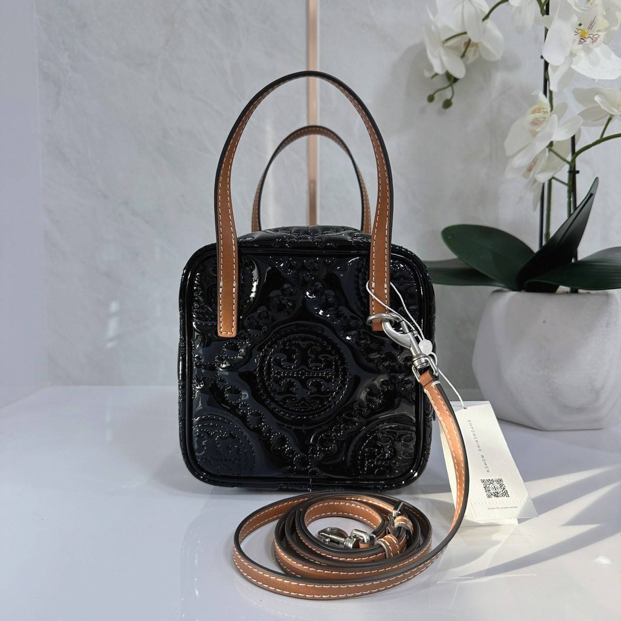 Tory Burch T Monogram Embroidered Patent Cube คอลเลคชั่นใหม่ รุ่นลิมิเต็ดรูปทรงใหม่ T Monogram สุดcube วัสดุหนังแท้ เปิด-ปิดด้วยซิป ภายในกว้าง มีช่องแยก 1 ช่อง สามารถใส่โทรศัพท์มือถือได้ทุกรุ่น สามารถถือหิ้วหรือสะพายได้ สายสามารถถอดและปรับระดับได้คะ